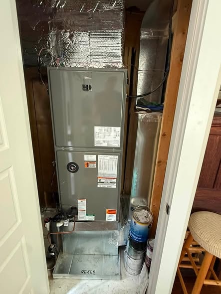 Air handler in a tall closet with the access door open for service