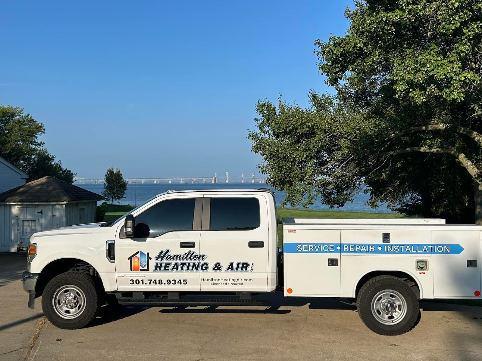 Hamilton Heating & Air service truck parked on Kent Island with the Chesapeake Bay Bridge behind it