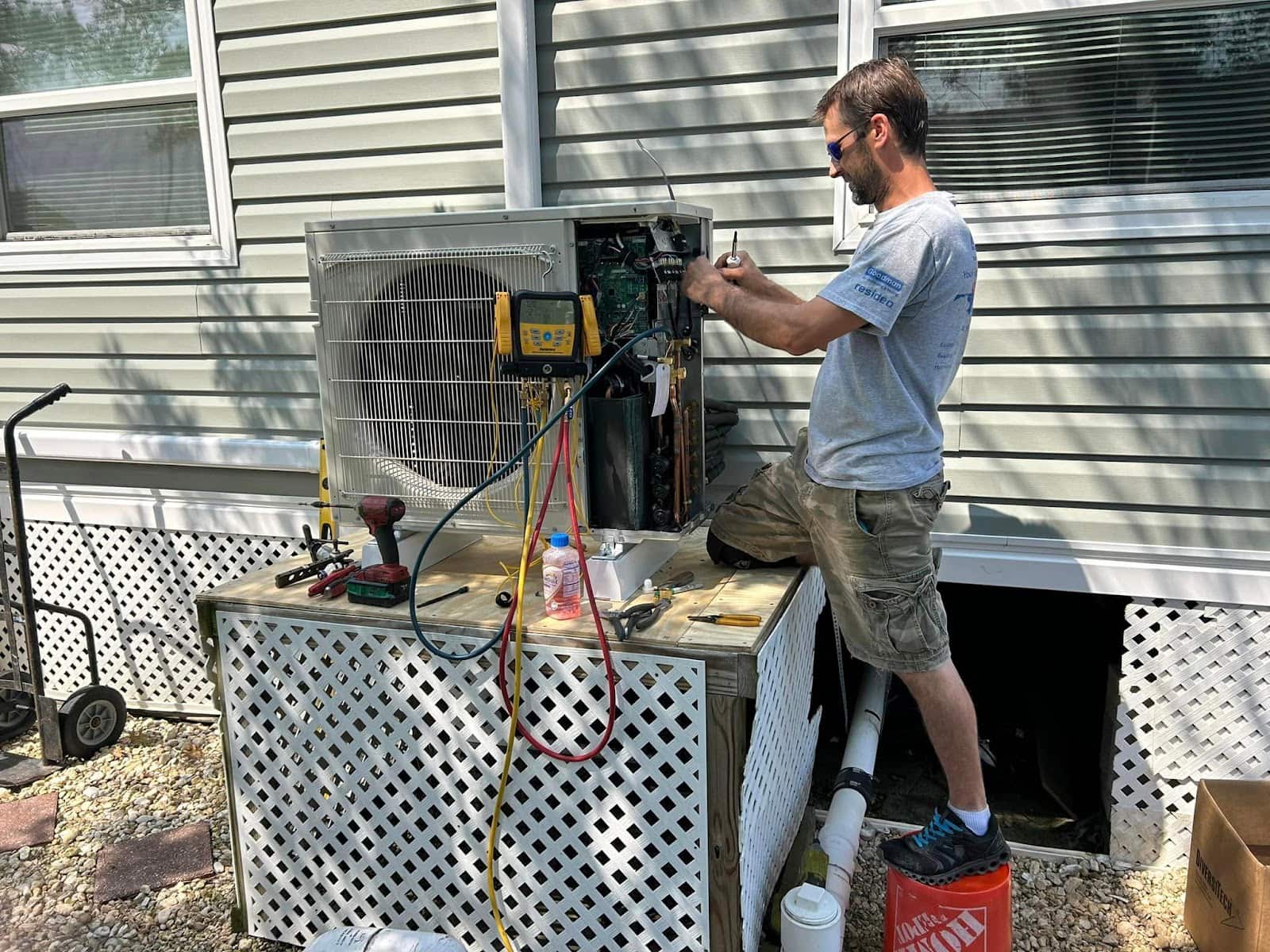 Hamilton technician working on an outdoor unit with refrigerant gauges hooked up