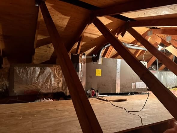 Attic air handler set on a platform between the rafters