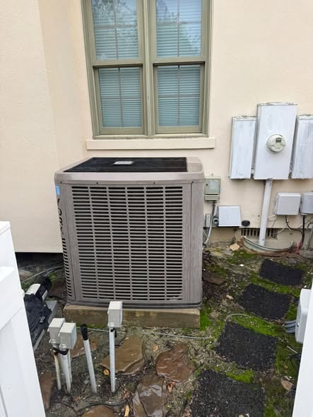 Outdoor condenser on a pad beside the electric meters