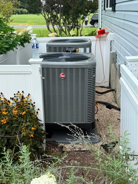 Outdoor units inside a white fence with flowers along the path